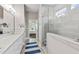 Bright bathroom boasts dual sinks, quartz countertop, and a glass enclosed shower at 102 Bella Rose Drive, Chapel Hill, NC 27517