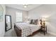 Bedroom featuring a bed with decorative pillows, a side table with a lamp, a full-length mirror, and neutral decor, creating a cozy space at 102 Bella Rose Drive, Chapel Hill, NC 27517