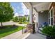 Inviting front porch with stone pillars, comfortable seating, and a view of the landscaped yard at 102 Bella Rose Drive, Chapel Hill, NC 27517