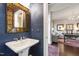 Elegant powder room with a designer mirror, pedestal sink, and stylish blue wallpaper at 102 Bella Rose Drive, Chapel Hill, NC 27517