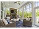 Cozy sunroom with a stone fireplace and comfortable wicker furniture at 102 Bella Rose Drive, Chapel Hill, NC 27517