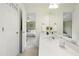 Bright bathroom with dual sinks, a large mirror, and an open layout leading to the bedroom at 102 W Hill Dr, Cary, NC 27519