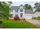 Charming two-story home with well-manicured lawn, beautiful landscaping, and attached two-car garage at 102 W Hill Dr, Cary, NC 27519