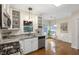 Bright kitchen with granite countertops, white cabinetry, stainless steel appliances, and breakfast nook at 102 W Hill Dr, Cary, NC 27519