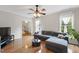 Bright living room with a ceiling fan, hardwood floors, and comfortable seating at 102 W Hill Dr, Cary, NC 27519