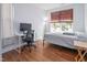 Bright bedroom featuring hardwood floors, a large window, and a dedicated workspace for studying or remote work at 1021 Benay Rd, Morrisville, NC 27560