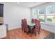 Elegant dining room area with hardwood floors, three large windows, and a stylish dining table with unique seating at 1021 Benay Rd, Morrisville, NC 27560