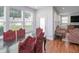Bright dining area featuring hardwood floors, a door, an ample window view, and modern lighting creating a cozy atmosphere at 1021 Benay Rd, Morrisville, NC 27560