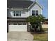 Charming two-story home featuring a gray exterior, stone accents, and an attached two-car garage, set against a blue sky backdrop at 1021 Benay Rd, Morrisville, NC 27560