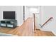 Hallway with a television and wood floors leading to staircase at 1021 Benay Rd, Morrisville, NC 27560