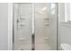 A pristine white shower stall featuring a glass door, convenient shelving, and modern fixtures at 1021 Benay Rd, Morrisville, NC 27560