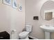 Well-lit powder room with pedestal sink, round mirror, and modern fixtures at 105 Putters Ct, Durham, NC 27703