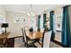 Formal dining room with wood table, updated lighting, and blue accent curtains at 105 Putters Ct, Durham, NC 27703