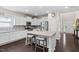 Bright kitchen features white cabinets, an island with seating, stainless steel appliances, and granite countertops at 105 Putters Ct, Durham, NC 27703
