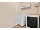 Functional laundry room with a washer, dryer, and shelving for storage at 105 Putters Ct, Durham, NC 27703