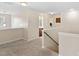 Open and airy loft area with neutral carpet, providing a versatile living space with a staircase at 105 Putters Ct, Durham, NC 27703