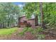 Exterior view of a two-story home with a large deck overlooking a lush, green backyard and mature trees at 105 Trailwood Ct, Chapel Hill, NC 27516