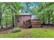 Back of house featuring a spacious deck with stairs leading down to the large, private wooded backyard at 105 Trailwood Ct, Chapel Hill, NC 27516