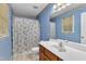Bathroom features a white vanity, large mirror, floral shower curtain, and blue walls at 105 Trailwood Ct, Chapel Hill, NC 27516