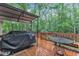 Deck featuring an outdoor grill and eating area, perfect for enjoying meals overlooking the wooded backyard at 105 Trailwood Ct, Chapel Hill, NC 27516