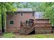 Rear exterior featuring a two-story home with a large wooden deck, accessed via sliding glass doors at 105 Trailwood Ct, Chapel Hill, NC 27516