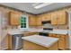 Bright kitchen features wood cabinets, stainless steel dishwasher, and a functional island perfect for food preparation at 105 Trailwood Ct, Chapel Hill, NC 27516