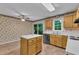 Cozy kitchen featuring wood cabinetry, an island with white countertop, and sliding door access to the deck at 105 Trailwood Ct, Chapel Hill, NC 27516