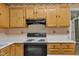 Kitchen with wooden cabinetry, white countertops, electric stove, and classic design at 105 Trailwood Ct, Chapel Hill, NC 27516