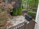 Private backyard featuring a stone patio, lush greenery, and a grill at 10579 Evergreen Spring Pl, Raleigh, NC 27614