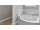 A luxurious soaking tub with tile surround and chrome fixtures at 10579 Evergreen Spring Pl, Raleigh, NC 27614
