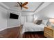 Cozy bedroom with hardwood floors, a ceiling fan, and a mounted television at 10579 Evergreen Spring Pl, Raleigh, NC 27614