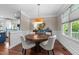 Bright dining room with hardwood floors, unique lighting fixture, window and blue furniture at 10579 Evergreen Spring Pl, Raleigh, NC 27614