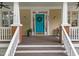 Inviting front porch featuring a bright blue door with wreath, white columns, and cozy outdoor space at 10579 Evergreen Spring Pl, Raleigh, NC 27614