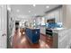 Open concept kitchen with blue island, stainless appliances, and adjacent living and dining areas at 10579 Evergreen Spring Pl, Raleigh, NC 27614