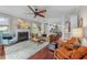 Comfortable living room featuring a fireplace, ceiling fan, neutral colors and hardwood flooring at 10579 Evergreen Spring Pl, Raleigh, NC 27614