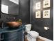 Stylish powder room featuring dark walls, copper sink, and modern fixtures at 108 Vescova Ln, Morrisville, NC 27560