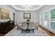 Elegant dining room with a glass table, upholstered chairs, wainscoting, and a decorative chandelier at 108 Vescova Ln, Morrisville, NC 27560