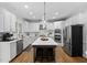 Spacious, white kitchen with a large island, stainless steel appliances and modern lighting at 108 Vescova Ln, Morrisville, NC 27560