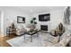 Bright living room with fireplace, large TV, stylish furniture and decor, and hardwood floors at 108 Vescova Ln, Morrisville, NC 27560
