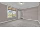 Neutral bedroom featuring a window with a view and an open doorway to another room at 1085 Lobdale Ct, Burlington, NC 27215