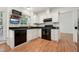 Eat-in kitchen features black appliances, granite counters, tile backsplash, and white cabinetry at 111 Catherwood Pl, Cary, NC 27518