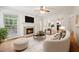 Cozy living room with a fireplace, hardwood floors, and a neutral colored sofa and ottoman at 111 Catherwood Pl, Cary, NC 27518