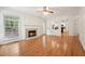 Bright living room with hardwood floors, a fireplace, and views into the adjacent kitchen at 111 Catherwood Pl, Cary, NC 27518