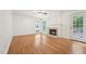 Cozy living room featuring a fireplace, hardwood floors, and windows overlooking the backyard at 111 Catherwood Pl, Cary, NC 27518
