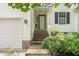 Exterior view showcasing the front door with brick steps and adjacent two-car garage at 1113 Pilton Pl, Raleigh, NC 27604