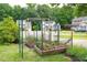 Attractive backyard vegetable garden with raised beds, supported by green archways for climbing plants at 1113 Pilton Pl, Raleigh, NC 27604