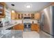 Well-lit kitchen featuring granite countertops, wooden cabinets, and stainless steel appliances at 1113 Pilton Pl, Raleigh, NC 27604