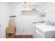 Well-lit laundry room features shelving, modern washer and dryer units, and an ironing board at 1113 Pilton Pl, Raleigh, NC 27604