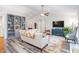 Living room features built-in shelving, a TV, wood floors, and comfortable seating at 1113 Pilton Pl, Raleigh, NC 27604