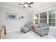 Bright sitting room featuring patterned armchairs, a ceiling fan, and natural light from a large window at 1113 Pilton Pl, Raleigh, NC 27604
